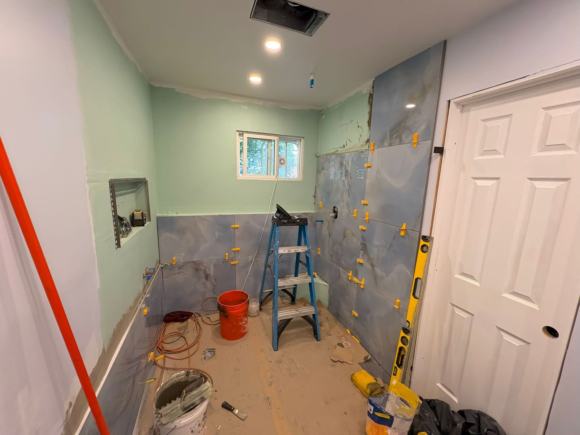 In-progress tile installation during a bathroom remodel by Urban Edge Construction in Cedar Rapids, Iowa.
